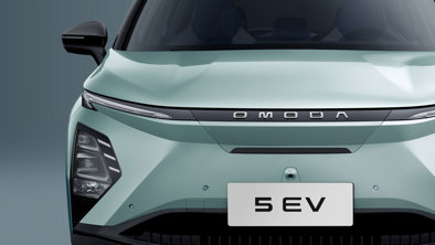 Frontbillede af en lysegrøn Omoda 5 EV elbil, der viser kølergrill, logo og nummerplade.