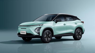 En lysegrøn kompakt SUV-elbil med sorte detaljer, set forfra fra venstre mod en ensfarvet baggrund.