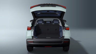 En lyseblå SUV set bagfra med åben bagklap, der viser et tomt lastrum og nedfældede bagsæder.
